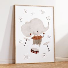 a poster with an elephant on it sitting in front of a white wall and wooden floor