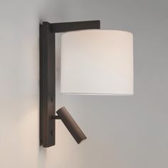 a wall light with a white shade on it