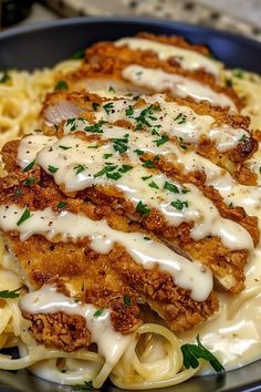 chicken parmesan on top of pasta in a blue bowl with gravy