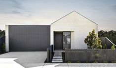 a house with a fence in front of it and grass on the ground next to it