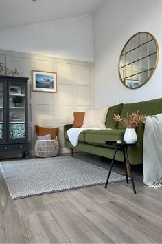 a living room filled with furniture and a rug on top of a hard wood floor