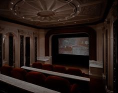 an empty theater with red seats and a projector screen in the middle of the room