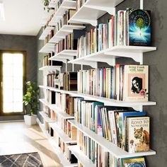 a bookshelf filled with lots of books next to a doorway and door way