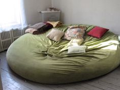 a large bean bag chair sitting on top of a wooden floor next to a window