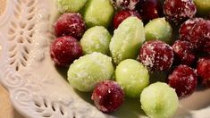 a white bowl filled with cranberry and green apples covered in powdered sugar