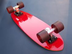 a red skateboard sitting on top of a blue surface with two wheels attached to it