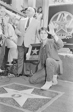 an old black and white photo of people on the hollywood walk of fame with their hands in the air