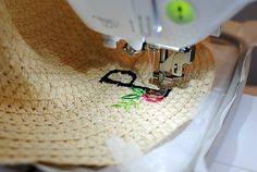 a close up of a sewing machine with a straw hat on it