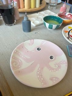 an octopus plate sitting on top of a table next to bowls and utensils