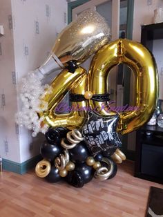 the balloon is in the shape of the number forty and it's surrounded by black and gold balloons