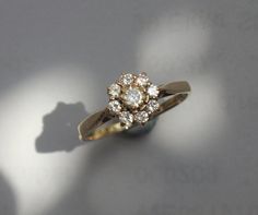 a diamond ring sitting on top of a white table next to a shadow cast object