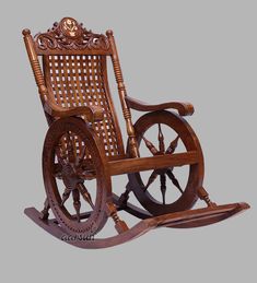 an old wooden rocking chair with wheels and spokes on the back, sitting in front of a gray background