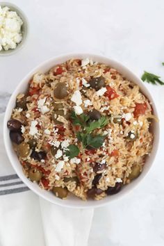 a white bowl filled with rice and olives