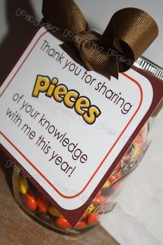 a jar filled with candy sitting on top of a table next to a sign that says, thank you for sharing pieces of your knowledge with this year