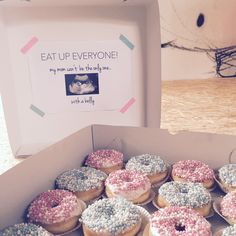 a box filled with donuts covered in sprinkles next to a sign that says eat up everyone