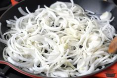 onions being cooked in a wok on the stove