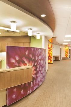 the interior of an office building with wood flooring and colorful artwork on the walls