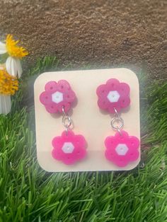 Two tiered pink Perler flower earrings. Perfect for summer☀️ nickel free Spring Pink Earrings With Handmade Flowers, Pink Earrings With Handmade Flowers For Spring, Pink Handmade Flower Earrings For Spring, Pink Flower Charm Drop Earrings, Pink Handmade Flower Drop Earrings, Pink Dangle Flower Earrings For Spring, Spring Pink Earrings With Flower Charm, Summer Pink Jewelry With 3d Flowers, Adjustable 3d Flower Earrings