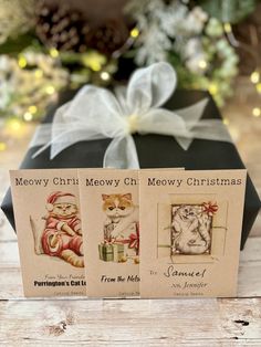 two christmas cards with pictures of cats and kittens in front of a present box