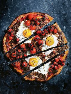 a pizza topped with eggs and cherry tomatoes