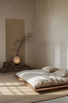 a bed with white sheets and pillows on top of it in a room next to a window