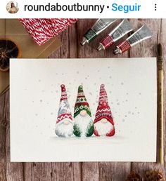 a card with three gnomes on it next to some christmas decorations and other items