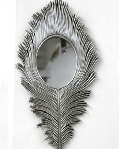 a mirror that is on the wall with a peacock feather design in it's center