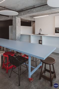 an empty table and chairs in a room with white walls, concrete floors and flooring