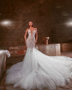 a woman in a wedding dress posing for the camera