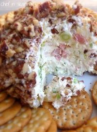 a close up of a cheese ball on a plate with crackers