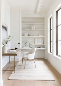 a white chair sitting in front of a desk next to a window