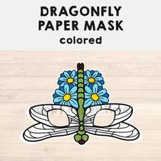 the dragonfly paper mask is decorated with blue flowers