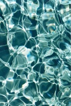 the water is reflecting sunlight and ripples on it's surface, creating an abstract pattern