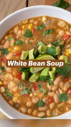 white bean soup with avocado and cilantro in a bowl on a wooden table