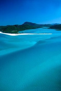 an aerial view of the blue water and sand dunes at white beach, whitland