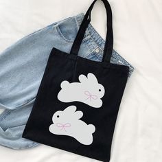 "Coming in 2 different colors, natural and black, with a super cute and simple bunny design, this canvas tote bag is a perfect complement to your daily outfit ୨୧🐇 ♡ More of Coquette Aesthetic: https://www.etsy.com/shop/RainieshopDesign?ref=seller-platform-mcnav§ion_id=1 ✮ ⋆ ˚｡  PRODUCT DETAILS  ⋆｡o✩ ✧ 100% cotton canvas ✧  Heavy fabric (12 oz/yd² (406.9 g/m ✧ Sewn-in label ✧ One size -15\" x 16\" (handles are 20\" long)   PRODUCT DETAILS  ▸ Hand wash ▸ Tumble dry: low heat ▸ Non-chlorine: bleach as needed ▸ Do not iron directly over the printed area - print may stick to the iron ▸ Do not dry clean ₊ ⊹₍ᐢᐢ₎ ♡ We truly appreciate your support and look forward to seeing your photos and reading your reviews. ♡ If you ever encounter any issues or have any questions, please reach out to us. Your Cute Everyday Bags With Bunny Design, Cute Bunny Design Bags For Everyday Use, Cute Bunny Design Bag For Everyday Use, Black Casual Reusable Bag, Casual Black Reusable Bag, Casual Black Canvas Bag As Gift, Cute Black Canvas Bag For Everyday, Cute Everyday Black Canvas Bag, Black Reusable Canvas Bag For Everyday