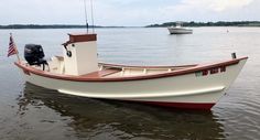 a small white boat floating on top of a lake next to a flag pole and an american flag