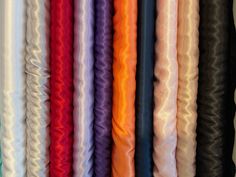 many different colored fabrics are lined up together