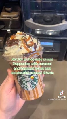 someone is holding up a starbucks cup with ice cream and caramel on it,