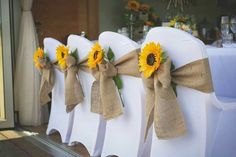 chairs with burlocks and sunflowers tied to them are ready for the ceremony