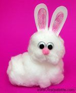 a white stuffed rabbit sitting on top of a pink surface