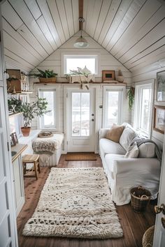 a living room filled with furniture and lots of wood flooring next to a white door