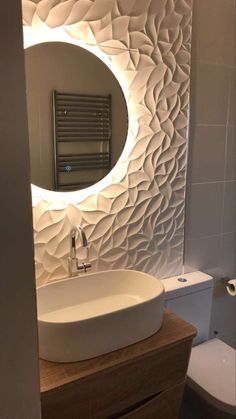 a white sink sitting under a round mirror