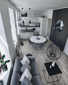 a living room filled with furniture next to a kitchen and dining room table on top of a hard wood floor