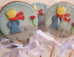 three decorated cookies on top of each other with white ribbons and bows in front of them