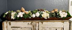 an old cabinet with flowers and stuffed animals on top