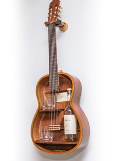 a wooden guitar shelf with bottles and glasses on it