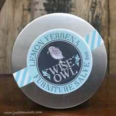 the wise owl furniture sale badge is on top of a wooden table next to a barrel