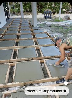 a man laying down cement on top of a floor