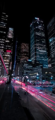 the city is lit up at night with bright lights and skyscrapers in the background